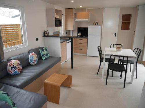ein Wohnzimmer und eine Küche mit Sofa und Tisch in der Unterkunft Blue Camargue - Le Grau du Roi in Le Grau-du-Roi