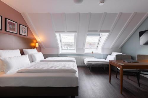 シュトゥットガルトにあるGarner Hotel Stuttgart City Centre by IHGのベッド2台と机があるホテルの部屋