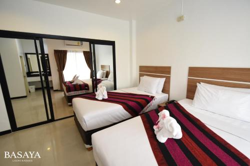 two beds in a hotel room with stuffed animals on them at Basaya Laemchabang in Ban Laem Chabang