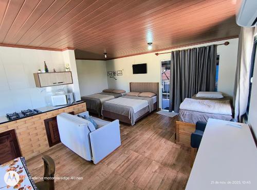 a hotel room with two beds and a living room at Acomodação Cambirela in Palhoça