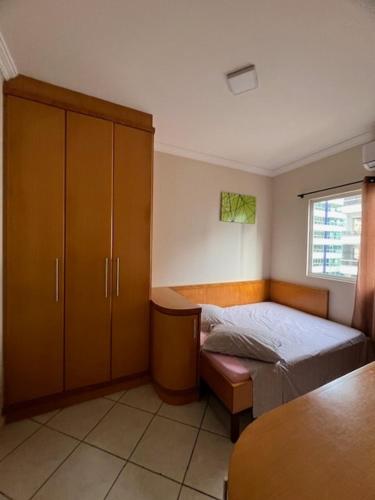1 dormitorio pequeño con 1 cama y armario en Apto a 80 metros do mar para 8 pessoas, en Itapema