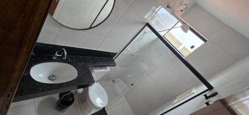 a bathroom with a sink and a mirror at Apartamento Barra Vento 2 in Guriri