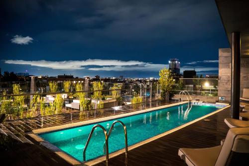 a pool on the roof of a building at night at Hotel Estelar Parque de la 93 in Bogotá