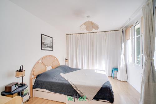 a white bedroom with a bed and a window at Orves - Seine-Saint-Denis - CI - Elegance and comfort with garden for 2 people in Le Pré-Saint-Gervais