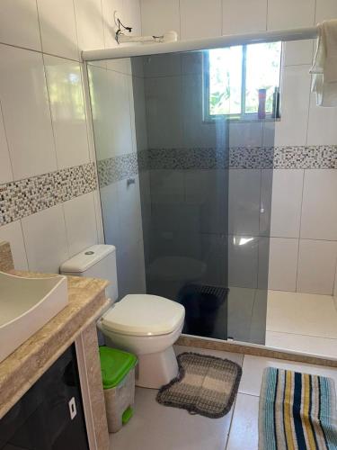 a bathroom with a toilet and a shower and a sink at Sitio do Piquira in São Francisco de Itabapoana