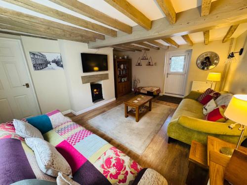 a living room with a couch and a fireplace at The Old Shop at Savile House - Sherwood Forest in Ollerton