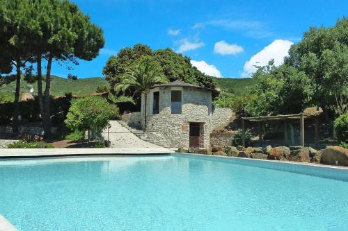 a swimming pool in front of a stone building at Residence La Chiusa di Rio, Rio nell'Elba in Rio nellʼElba