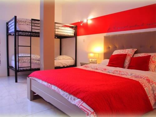 a bedroom with two bunk beds and a red bedspread at Le Mas de la Verrerie in Les Adrets de l'Esterel