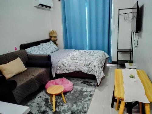 a living room with a bed and a couch at Oshanbyu Transient Home in Basbas