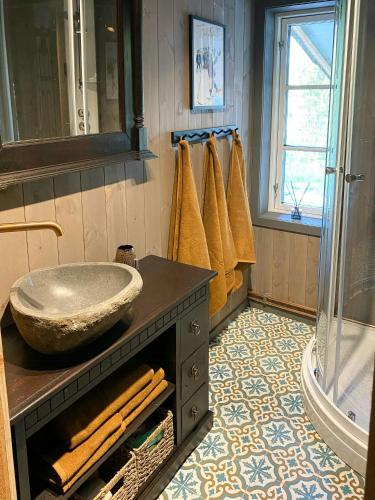 a bathroom with a sink and a glass shower at Renovated Cabin With Views In Trysil in Ljørdal