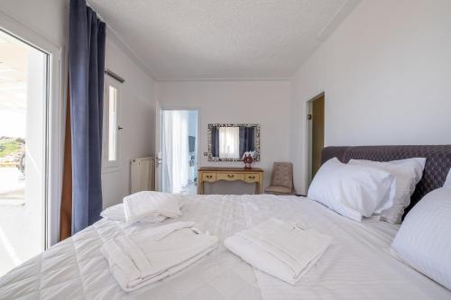 a bedroom with a white bed with towels on it at 3 Paros All Season Villas in Parikia