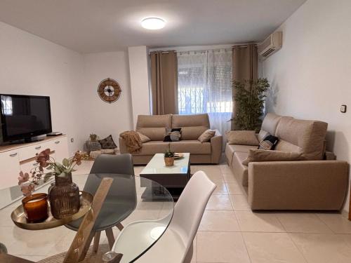 un soggiorno con un divano e un tavolo di CASA FAMILIAR LA ZUBIA - Granada a La Zubia