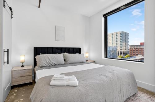 a bedroom with a large bed and a large window at Downtown Tulsa Beacon Getaway in Tulsa