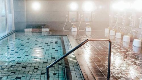 a bathroom with a swimming pool with toilets at 熱海の隠れ里 in Atami