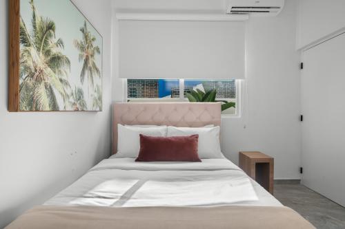 圣胡安Casa Placita Hotel的一间卧室配有一张带红色枕头的大床