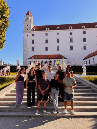 a group of people standing on steps in front of a building at Wild Elephants Hostel in Bratislava