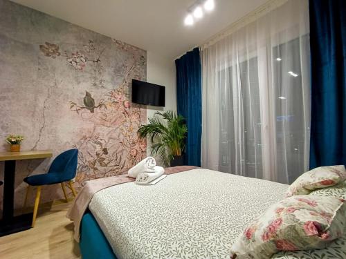 a bedroom with a bed and a chair and a window at AmaMolto Gardens in Wrocław