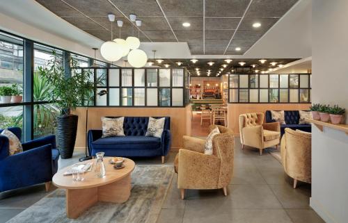 a lobby with blue couches and a table and chairs at Citadines Barbican London in London