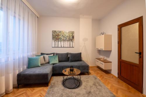 un soggiorno con un divano e un tavolo di NDK Garden at Vitosha Blvd Absolutely Top Center with Free Parking a Sofia