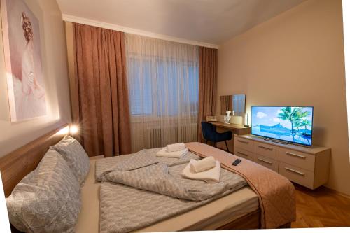 una camera da letto con un letto e una TV a schermo piatto di NDK Garden at Vitosha Blvd Absolutely Top Center with Free Parking a Sofia