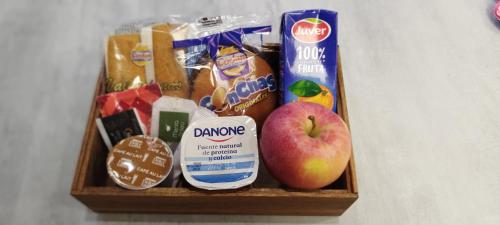 ein Korb mit Lebensmitteln, einem Apfel und Snacks in der Unterkunft Residencia Universitaria Resa Giner de Los Ríos in Alcalá de Henares