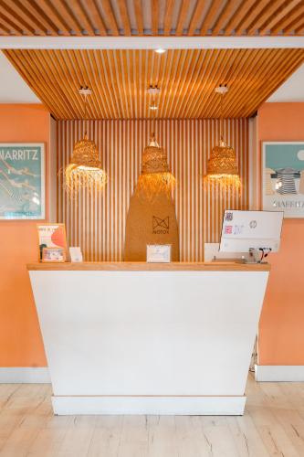 a counter in a store with a laptop on it at Hotel de l'Océan et restaurant - Coeur de ville in Biarritz