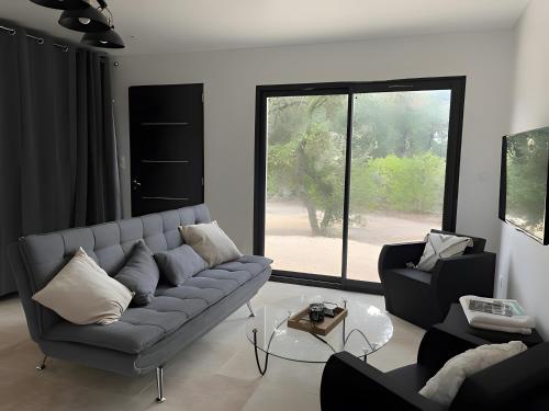 BuzignarguesにあるMaison Nichée Au Cœur Des Pinsのソファと窓のあるリビングルーム