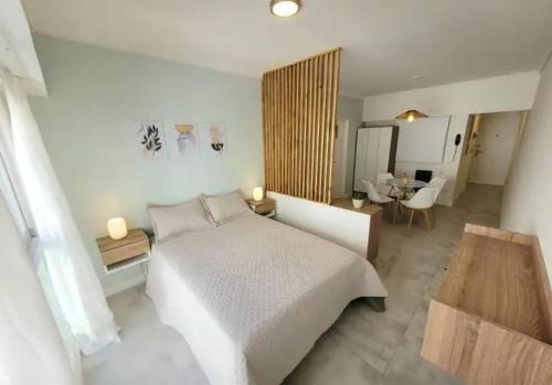 a bedroom with a large white bed and a desk at Edificio LA CENICIENTA in Mar del Plata