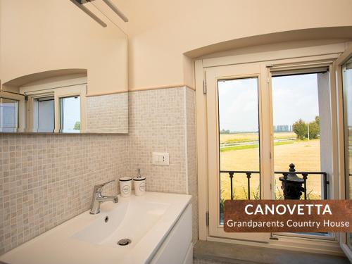 a bathroom with a white sink and a window at Canovetta Country Houses - nearby Cremona in Dosimo