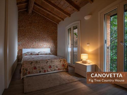 a bedroom with a bed and a brick wall at Canovetta Country Houses - nearby Cremona in Dosimo