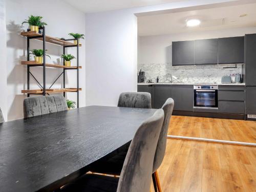 a dining room with a black table and chairs at Host & Stay - Stanley Street Apartments in Liverpool