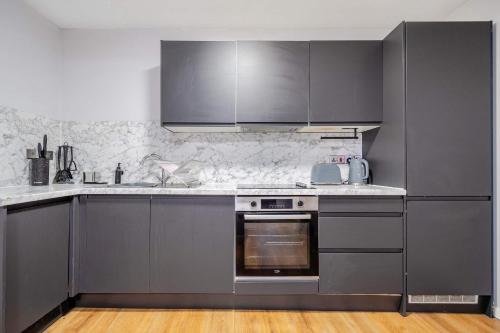 a kitchen with stainless steel appliances and gray cabinets at Host & Stay - Stanley Street Apartments in Liverpool