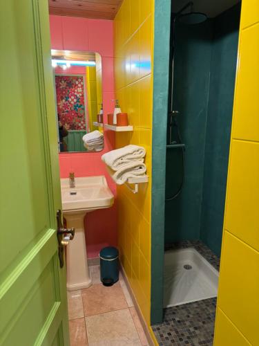 un bagno colorato con lavandino e doccia di Chèvreroche a La Bresse