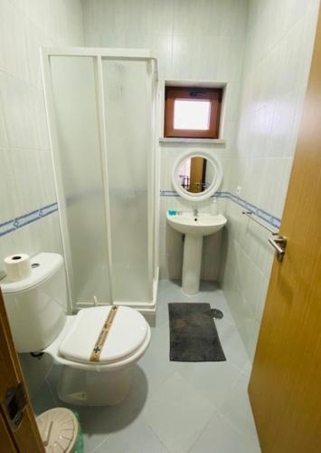 a bathroom with a toilet and a shower and a sink at SwordFish Fortress View in Peniche