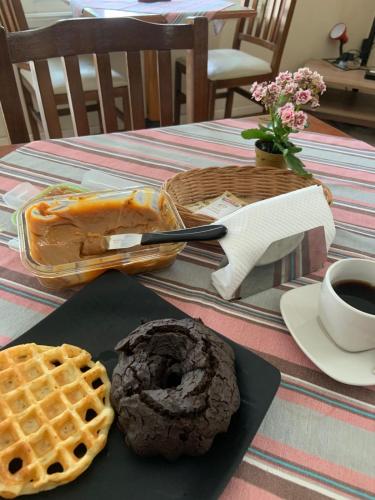 a table with a chocolate doughnut and a waffle at Guest House C da Montanha in Rio de Janeiro