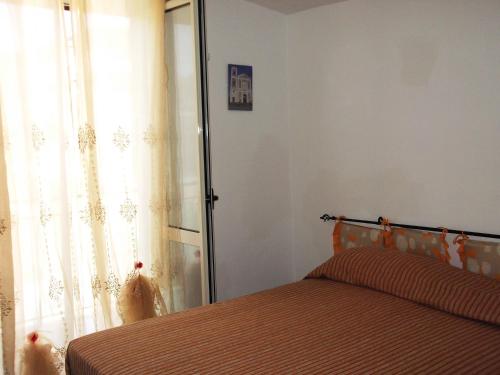 a bedroom with a bed and a window with curtains at B&B Da Rosa Camerota in Camerota