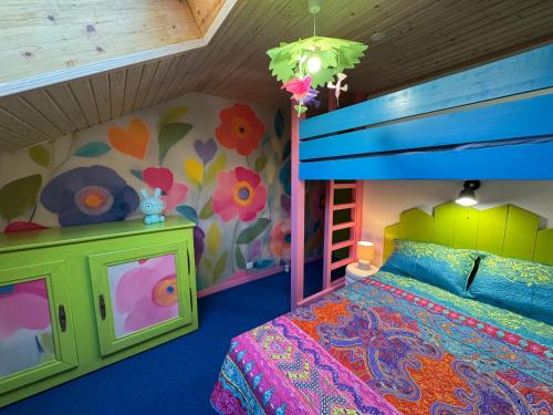 una camera da letto per bambini con un letto a castello e un murale floreale di Chèvreroche a La Bresse