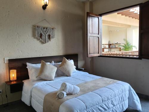 a bedroom with a bed with a towel on it at Hotel Boutique Lomas Colonial in Santa Fe de Antioquia