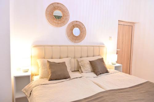 een slaapkamer met een groot bed met 2 spiegels aan de muur bij Villa Natalia in Kremen