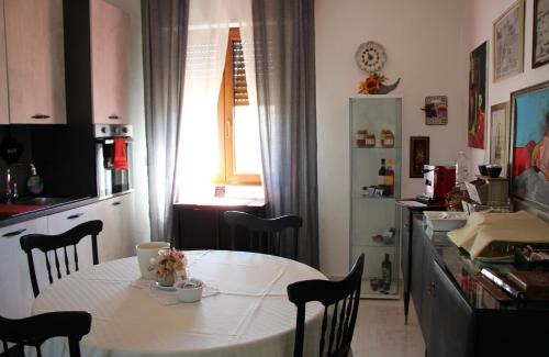 AgriBnB Casa Furnaredda في Laurenzana: مطبخ بطاولة بيضاء وطاولة وكراسي