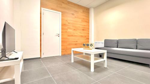 una sala de estar con un sofá y una mesa en Orléan 41 A centre-gare-aéroport, en Charleroi