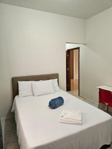 a white bed with a blue towel on it at Suite Campina - Business Hotel in Campina do Monte Alegre