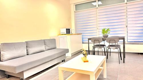 una sala de estar con un sofá y una mesa en Orléan 41 A centre-gare-aéroport, en Charleroi