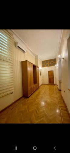 une grande pièce vide avec parquet et une pièce avec une fenêtre dans l'établissement Günlük evlər, à Baku