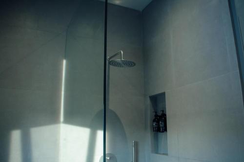 eine Dusche mit Glastür im Badezimmer in der Unterkunft Greywood in Gili Trawangan