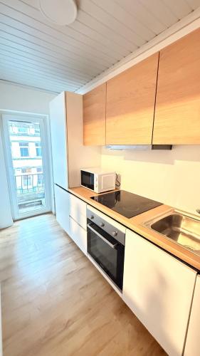 a kitchen with a sink and a microwave at Orléan 41 C centre-gare-aéroport in Charleroi