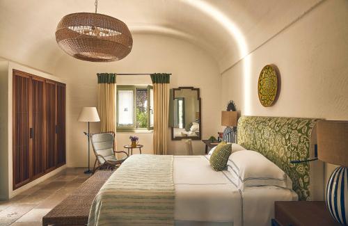 Un dormitorio con una cama y una silla en una habitación. en Rocco Forte Masseria Torre Maizza, en Savelletri di Fasano