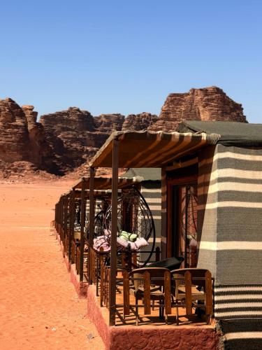 una fila di tavoli e sedie nel deserto di Rolx wadi rum a Wadi Rum