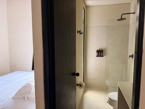 a bathroom with a bed and a toilet and a sink at Casamía in Medellín