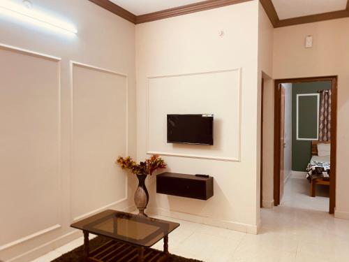 a living room with a tv on a wall at AL MANAL K-002 Premium 2BHK Retreat in Bhatkal